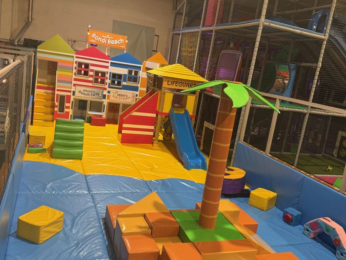 Bondi Beach themed toddler play area with beach huts and a slide